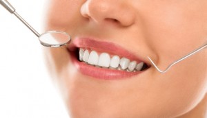 A woman is smiling while being at the dentist